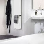 Modern design infrarood paneel badkamer als handdoekdroger naast een wastafel en ligbad